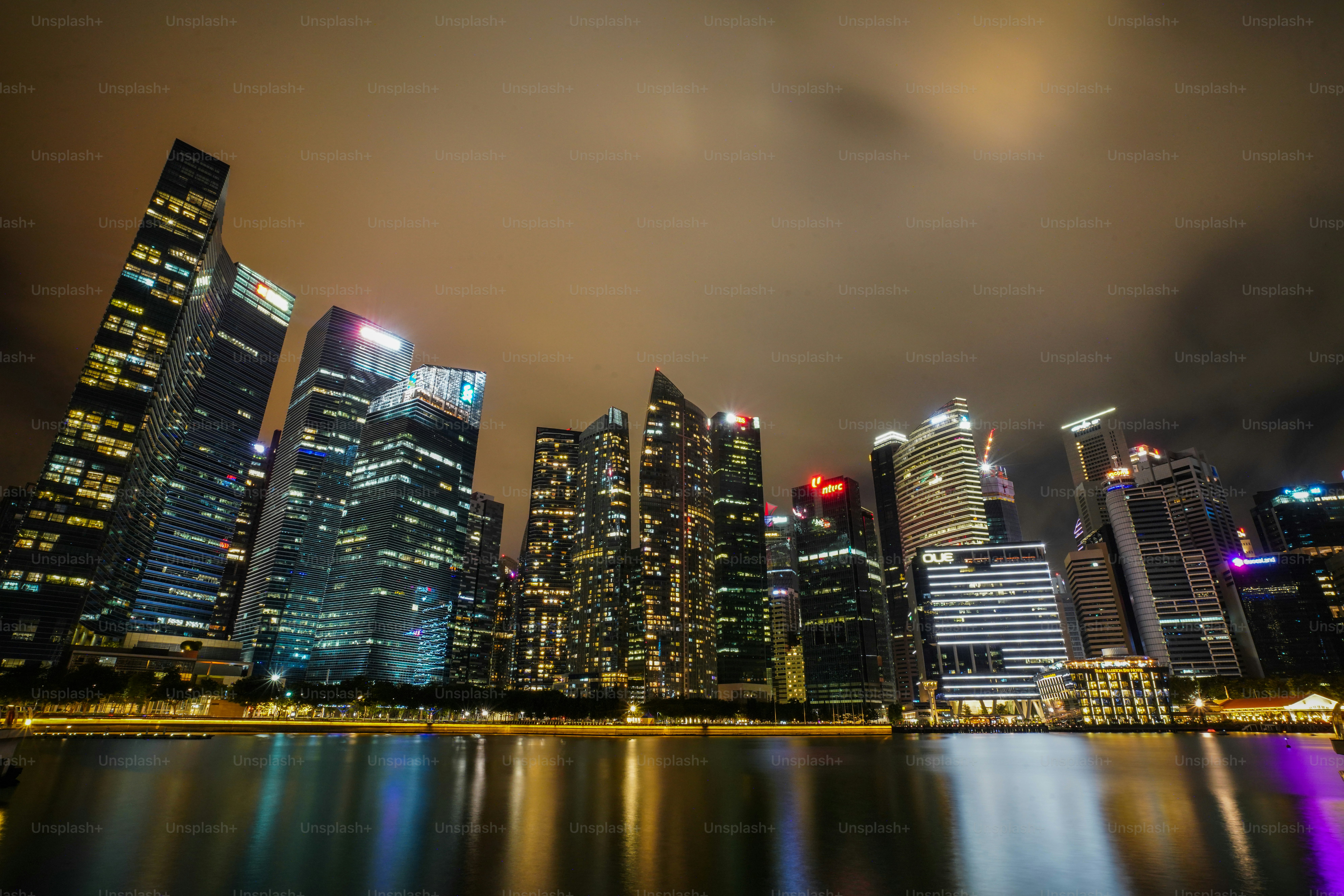 a city at night with lights reflecting in the water